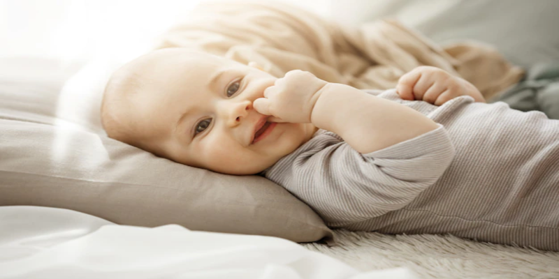 four-month-old baby putting his finger in his mouth